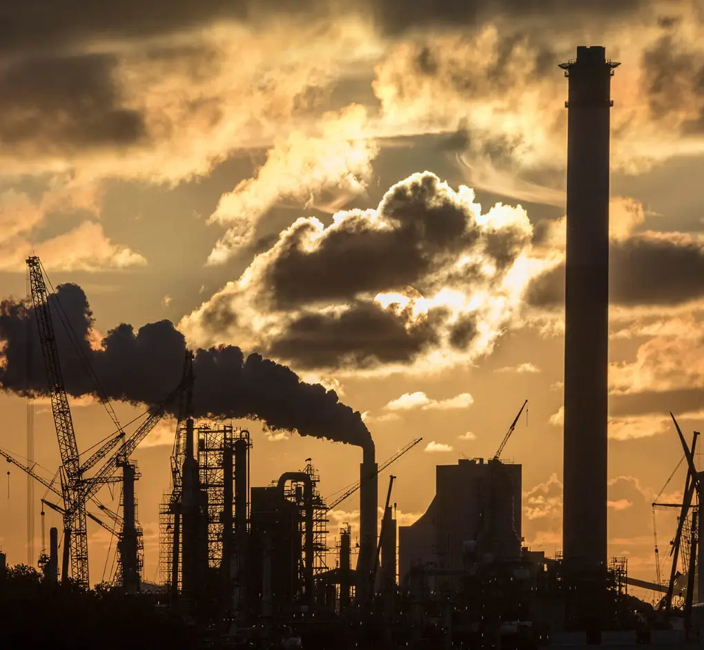 Clouds above an industrial facility representing the transition to a cleaner, low-carbon future